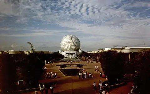 Spaceship Earth and the plaza at EPCOT Center in 1983, with guests walking toward the fountain