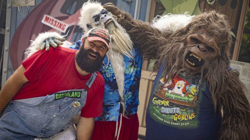 A Gatorland wrangler with costumed Yeti and Skunk Ape characters at Gators, Ghosts & Goblins